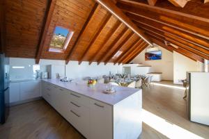a kitchen with white cabinets and a wooden ceiling at L'Incanto dei Monti in Agerola
