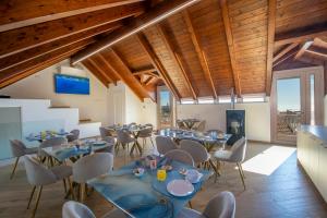 a dining room with tables and chairs and wooden ceilings at L'Incanto dei Monti in Agerola