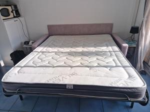 a bed in a bedroom with a mattressvisorvisorvisor at Studio cabine tout équipé in Le Lavandou