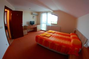 a bedroom with a bed with two yellow towels on it at Hotel Akre in Kavarna