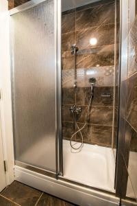 y baño con ducha y puerta de cristal. en Kars-i Si̇ri̇n Otel, en Kars