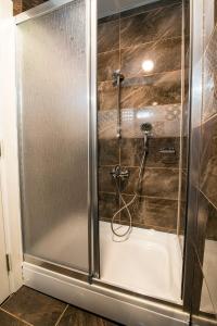 a shower with a glass door in a bathroom at Kars-i Si̇ri̇n Otel in Kars