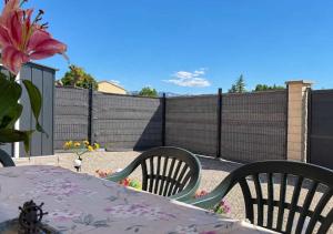 a patio with a table and chairs and a fence at Chambres d'hôtes Drome in Chatuzange-le-Goubet +7 photos