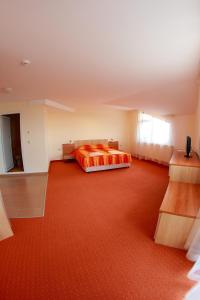 a bedroom with a bed and a red carpet at Hotel Akre in Kavarna