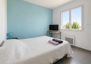 a bedroom with a white bed and a television at Chambres d'hôtes Drome in Chatuzange-le-Goubet