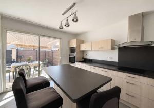 a kitchen with a table and chairs and a dining room at Chambres d'hôtes Drome in Chatuzange-le-Goubet