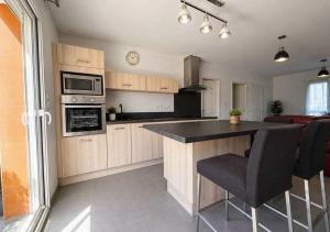 a kitchen with wooden cabinets and a black counter top at Chambres d'hôtes Drome in Chatuzange-le-Goubet