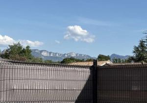a fence with a mountain in the background at Chambres d'hôtes Drome in Chatuzange-le-Goubet