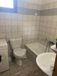 a bathroom with a toilet and a tub and a sink at Της κυρα Τασιας in Konitsa +6 photos