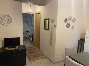 a living room with a desk and a clock on the wall at Της κυρα Τασιας in Konitsa