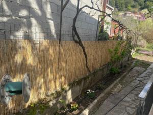 a fence in front of a house with a green chair at Της κυρα Τασιας in Konitsa