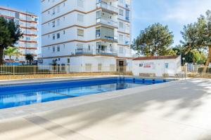 an apartment with a swimming pool in front of a building at Terrasol San Francisco 5ª Planta in Torre del Mar