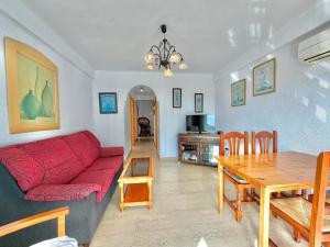 a living room with a red couch and a table at Terrasol San Francisco 5ª Planta in Torre del Mar