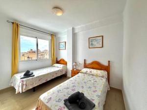 a bedroom with two beds and a window at Terrasol San Francisco 5ª Planta in Torre del Mar +14 photos