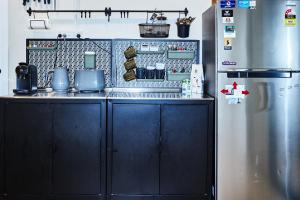 a kitchen with black cabinets and a stainless steel refrigerator at Lismore Hillside Home on Ballina Road in Lismore