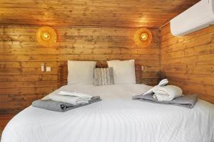a bedroom with a white bed with wooden walls at Cabane Spa - Noyers - Proche Sarlat in Jayac +20 photos