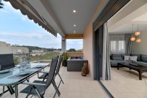 a living room with a table and chairs on a balcony at Lagonisi luxurious residence Nelly's Jacuzzi house in Kalívia Thorikoú