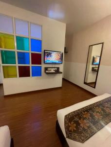 a room with colorful windows and a bed and a mirror at Hotel O Village in Baling