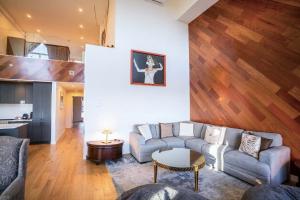 a living room with a couch and a table at 408 - Modern Condo - Pool & Panoramic View in Baie-Saint-Paul
