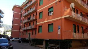 an orange building with cars parked in front of it at Sportrek House in Levanto