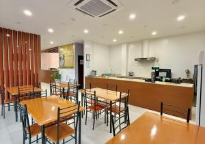 a restaurant with wooden tables and chairs and a kitchen at Cris Inn Samal in Samal