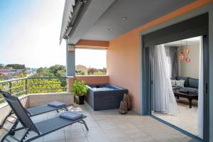 a balcony with a hot tub and a table and chair at Lagonisi luxurious residence Nelly's Jacuzzi house in Kalívia Thorikoú