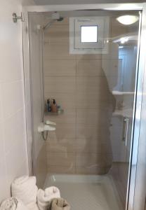 a bathroom with a shower with a glass door at BeCozy in Thérissos