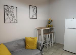 a living room with a couch and a table and a refrigerator at BeCozy in Thérissos +6 photos
