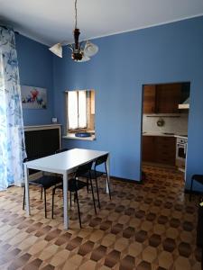a dining room and kitchen with a white table and chairs at La Ceramica in Appignano