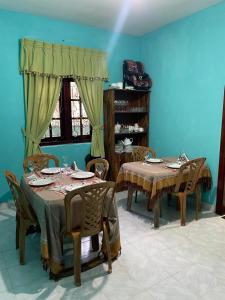 two tables and chairs in a room with blue walls at Ciel Grand 99 Villa in Katugastota
