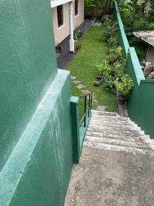 a green building with stairs and a green wall at Ciel Grand 99 Villa in Katugastota +8 photos