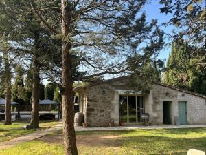 a stone building with a tree in the foreground at Château Borie Neuve in Badens