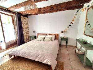 a bedroom with a bed and two tables and a window at La Source de Diège in Loupiac +48 photos
