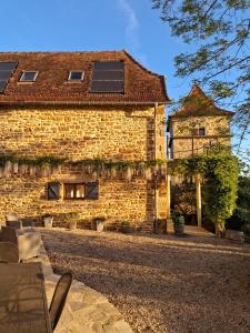a brick building with solar panels on the roof at La Source de Diège in Loupiac