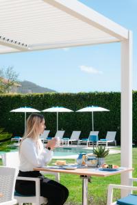 a woman sitting at a table under a pergola at Divina Costiera in Agerola +56 photos