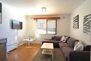 a living room with a couch and a table at Alpine Haven 5 in Mount Hotham