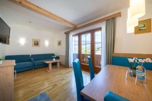 a living room with a table and a blue couch at Wellness Landhaus Parth in Ossiach