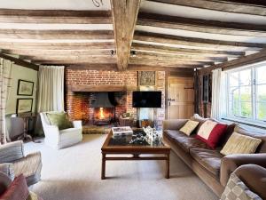 a living room with a couch and a fireplace at Cottage Farm by The Suffolk Cottage Collection in Offton