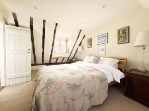 a bedroom with a bed with a white comforter at Cottage Farm by The Suffolk Cottage Collection in Offton