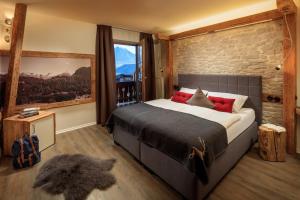 1 dormitorio con 1 cama grande y pared de piedra en Landhaus Mucha - Ferienwohnungen - Naturpark Partner, en Bolsterlang