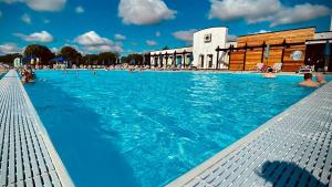 a large swimming pool with people in the water at 26 The Meadows in Tattershall
