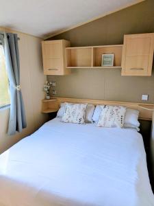 a bedroom with a large white bed with pillows at 26 The Meadows in Tattershall