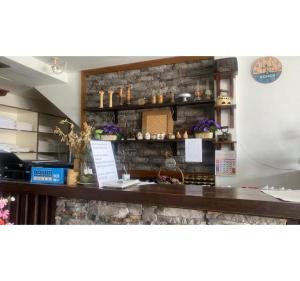 a bar in a restaurant with a stone wall at Hotel O Village in Baling