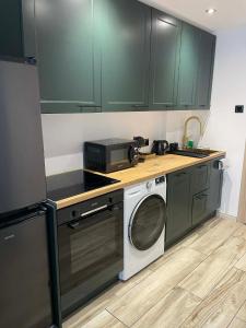 a kitchen with a washing machine and a microwave at Sikalafo in Płock