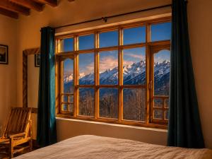 a bedroom window with a view of a mountain at Pema's Cottage by Outback Escapes in Kaza +20 photos