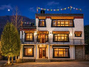 a large white brick building with windows at night at Pema's Cottage by Outback Escapes in Kaza