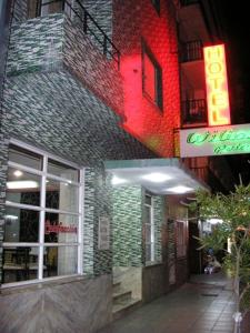 a building with a neon sign on the side of it at Hotel Wilton in Mar del Plata