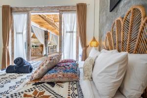 a bedroom with a bed and a large window at Villa deluna in Jimbaran +38 photos