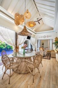 a dining room with a glass table and chairs at Villa deluna in Jimbaran