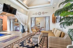 a living room with a couch and a tv at Villa deluna in Jimbaran